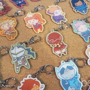 May include: A collection of colorful Overwatch character keychains featuring various characters from the game. The keychains are made of a durable material and feature detailed artwork of each character.