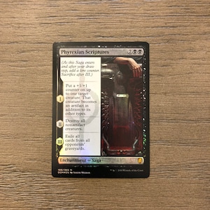 May include: Phyrexian Scriptures, a black and red Magic: The Gathering card with a silver border. The card is a saga enchantment with three chapters. The card text reads: "(As this Saga enters and after your draw step, add a lore counter. Sacrifice after III.) I - Put a +1/+1 counter on up to one target creature. That creature becomes an artifact in addition to its other types. II - Destroy all nonartifact creatures. III - Exile all cards from all opponents' graveyards."