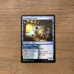 May include: A blue and white Magic: The Gathering card with the text "Animating Faerie" and "Bring to Life". The card features a blue and white illustration of a faerie.