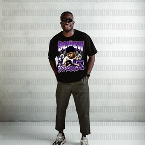 May include: Black t-shirt featuring a graphic of a man with the text "DJ SCREW SCREWHEAD" in purple and white. The person in the image is wearing sunglasses, olive green trousers, and grey and white trainers.