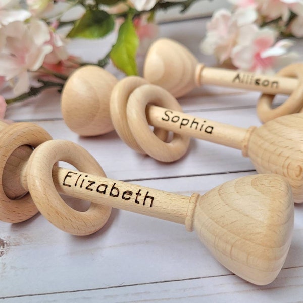 Jingling rings wooden toy rattle. Option to personalize with baby name for an extra special newborn photo prop and cherished momento.