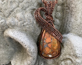 Brecciated jasper cabochon wire wrapped and wire weaved with copper wires and hung from a copper plated chain.