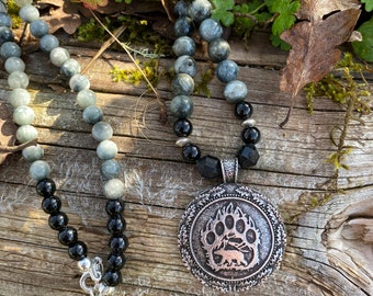 Bear paw print pendant (reversible) hung from a strand of Eagle's eye, black onyx and black tourmaline beads with silver accents.