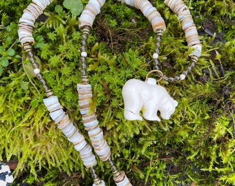 Polar bear pendant carved from ethically sourced bone hung from a strand of smoky quartz, bone and shell beads.