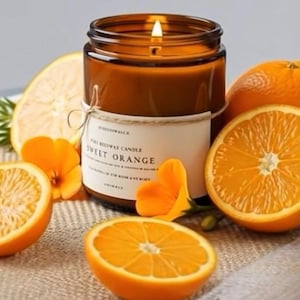 May include: A lit candle in a brown glass jar with a white label reading Sweet Orange, surrounded by several halved and whole oranges and small orange flowers. The candle features a visible flame and is tied with a thin piece of twine.