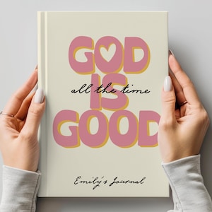 May include: A pink and yellow journal with the text "GOD is GOOD all the time" and the words "Emily's Journal" at the bottom.