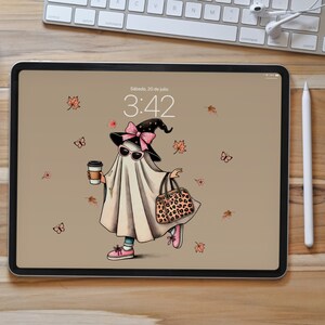 May include: A digital illustration on a tablet shows a ghost character wearing sunglasses, a witch hat with a pink bow, and carrying a coffee cup and a leopard print bag. The background is tan with falling leaves and butterflies.