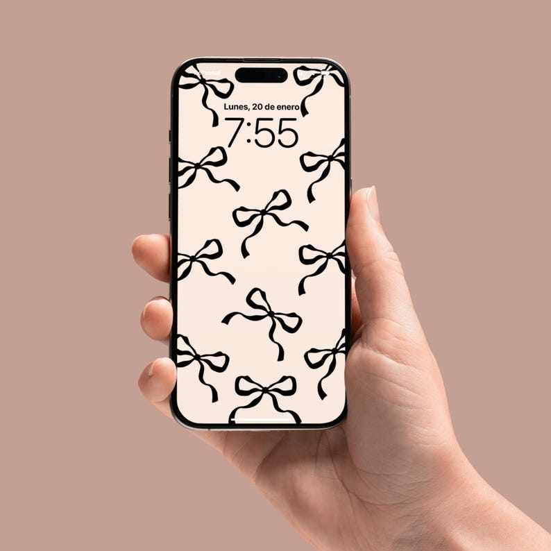 May include: A smartphone with a white background and a black bow pattern. The time is 7:55 and the date is Lunes, 20 de enero.