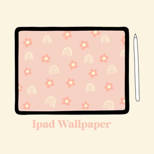 Puede incluir: Una tableta digital con un fondo rosa y un patrón de arcoíris blancos y flores rosas. El texto "iPad Wallpaper" está debajo de la tableta. Un lápiz blanco está a la derecha de la tableta.