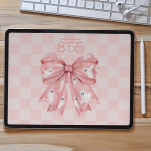 May include: A pink and white bow with a checkered background. The bow is decorated with white ghosts. The text "Domingo, 4 de agosto" and "8:55" are displayed on the screen.