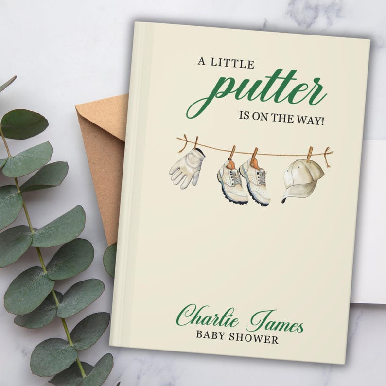 May include: A cream-coloured baby shower invitation with the text "A Little Putter Is On The Way!" in green script. The illustration shows a golf glove, shoes, and a hat hanging on a clothesline. The name "Charlie James" and "Baby Shower" are also printed.