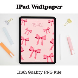 May include: A pink iPad wallpaper with a pattern of pink watercolor bows. The time is 15:42 on the screen.