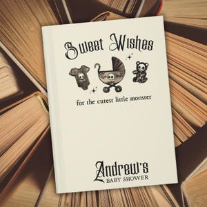 May include: A white baby shower card with the text "Sweet Wishes" and "for the cutest little monster." The card features illustrations of a onesie, stroller, and teddy bear, each with a skull design. The card is personalized with the name "Andrew's" and "BABY SHOWER."