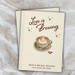 May include: Two stacked cream-colored books with the text "Love is Brewing" and a coffee cup illustration. The cup is on a saucer with a spoon and coffee beans. Below is "Sara's Bridal Shower, September 28, 2025."