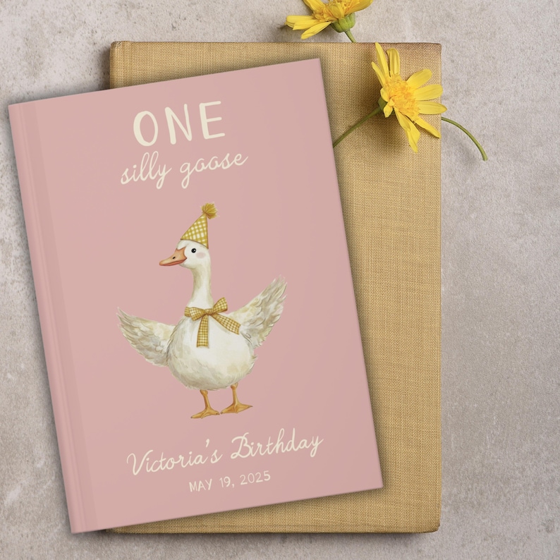 Puede incluir: Un libro rosa con la frase "ONE silly goose" y una ilustraci&oacute;n de un ganso con gorro de fiesta y pajarita. El libro tambi&eacute;n incluye el texto "Victoria's Birthday MAY 19, 2025".