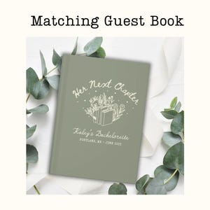 Op de afbeelding: Saliegroen gastenboek met de tekst "Her Next Chapter" en "Kaley's Bachelorette, Portland, ME - June 2025". De cover heeft een bloemen- en boekillustratie in wit. De woorden "Matching Guest Book" staan bovenaan.