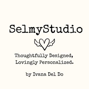 May include: White background with the text "SelmyStudio" in a bold, black, typewriter-style font. Below the text is a heart with wings. The text "Thoughtfully Designed, Lovingly Personalized. by Ivana Del Do" is also present.