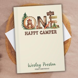Personalized “One Happy Camper” birthday guestbook for baby’s first birthday, featuring woodland-themed illustrations with a bear, fox, tent, and trees. Custom cover with child's name “Wesley Preston” and “First Birthday” text. Perfect keepsake photo album and memory book.