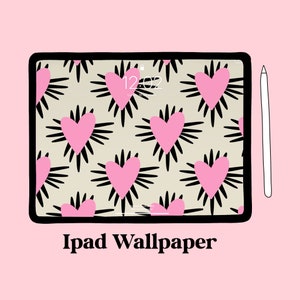 May include: A black iPad with a pink heart pattern wallpaper and a white Apple Pencil. The iPad screen shows the time 12:02. The text "iPad Wallpaper" is below the iPad.