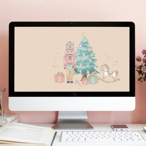 Puede incluir: Una pantalla de ordenador que muestra una ilustración digital de un cascanueces de pie junto a un árbol de Navidad decorado, un caballo de balancín y regalos envueltos. El fondo es de color beige claro con purpurina dorada.