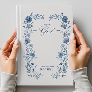 May include: A white journal with a blue floral design on the cover. The text "Dear God" is written in a cursive font. The text "Letters from Rachel" is written below the floral design.