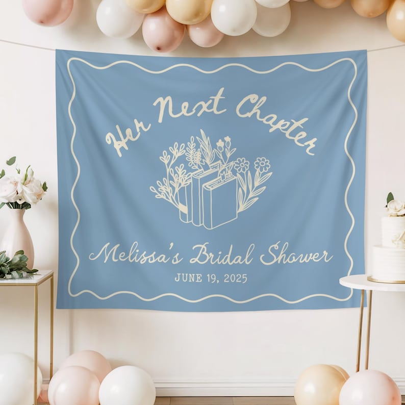 Op de afbeelding: Een lichtblauwe banner met de tekst "Her Next Chapter" en "Melissa's Bridal Shower" in een scriptlettertype. De banner heeft een bloemen- en boekontwerp. De datum "June 19, 2025" is ook opgenomen. Een witte geschulpte rand omlijst de tekst.