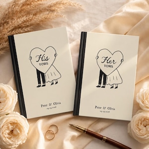 May include: Two cream-colored vow books with black spines. Each cover features a black line drawing of a couple holding a heart with the text 'His vows' or 'Her vows'. Below, the text 'Peter & Olivia' and '09.19.2026' is printed in black ink.