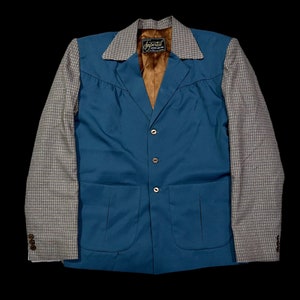 Può includere: Un blazer blu turchese con un motivo a quadri sulle maniche. Il blazer ha una chiusura con bottoni e due tasche. L'etichetta sul blazer recita "Imperial Sportswear".