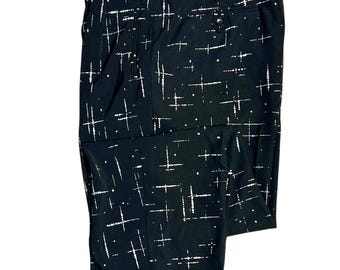 May include: Black pants with a white geometric pattern. The pants have a cuffed hem and a button fly.