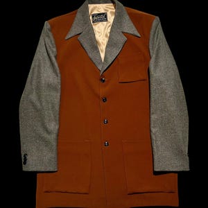 May include: A vintage rust-colored jacket with gray houndstooth sleeves and collar. The jacket has a tailored fit with a notched collar, three buttons, and two front pockets. The interior lining is a light gold color. The label reads "Imperial Tailoring".