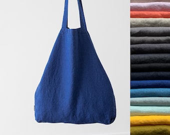 Può includere: Una grande borsa tote in lino blu con ampi manici. La borsa è realizzata in un tessuto morbido e naturale e ha un aspetto rilassato e casual.