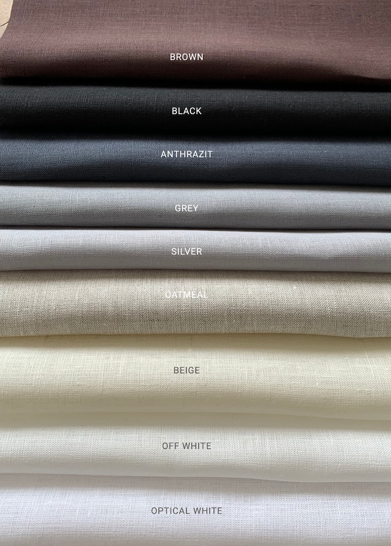 May include: A stack of fabric swatches in various shades of white, beige, gray, black, and brown. The swatches are labeled with their color names: Optical White, Off White, Beige, Oatmeal, Silver, Grey, Anthrazit, Black, and Brown.