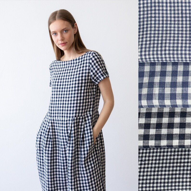 May include: A white and navy blue gingham dress with short sleeves and a boat neck. The dress has a gathered skirt and pockets on the sides.