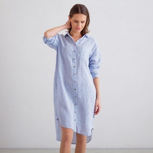 Puede incluir: Un vestido camisa de lino a rayas azul claro y blanco con cierre de botones y un dobladillo alto-bajo.