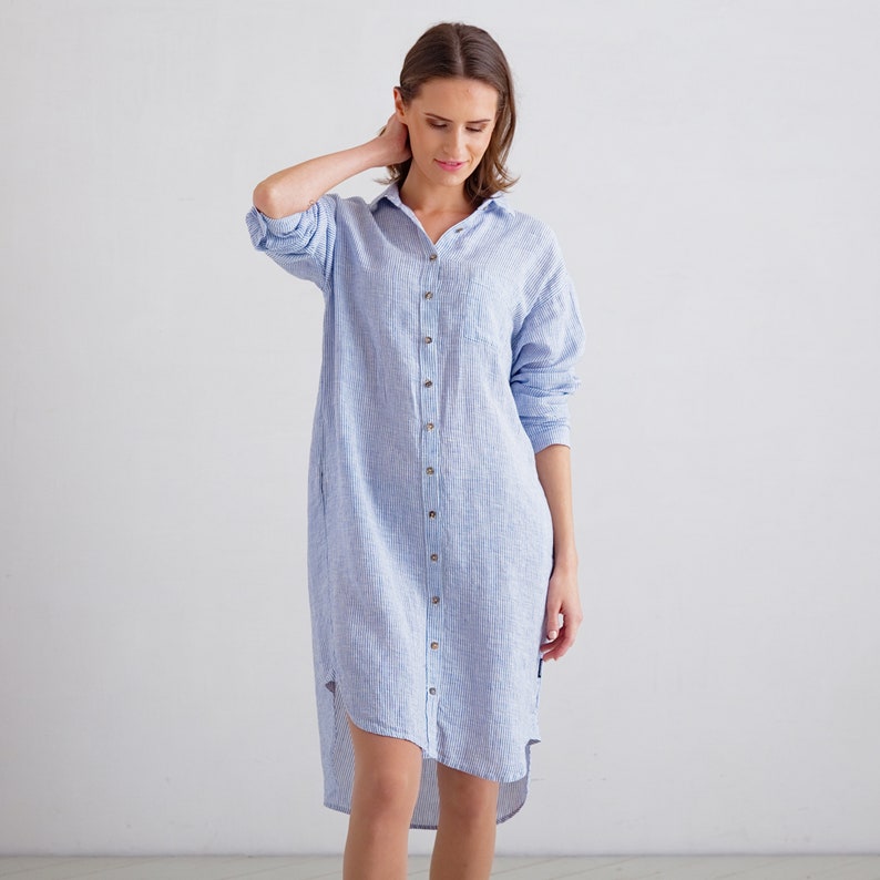 Puede incluir: Un vestido camisa de lino a rayas azul claro y blanco con cierre de botones y un dobladillo alto-bajo.