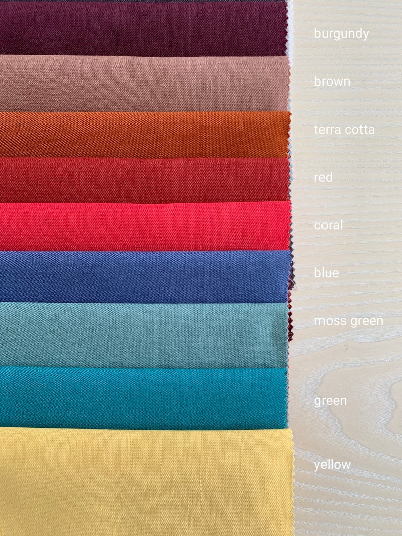May include: A fabric swatch card with 10 different colors of fabric. The colors are burgundy, brown, terra cotta, red, coral, blue, moss green, green, yellow, and a light yellow.
