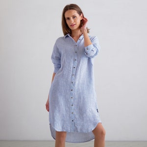 Puede incluir: Un vestido camisa de lino a rayas azul claro y blanco con cierre de botones y un dobladillo alto-bajo.