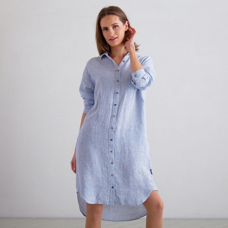 Puede incluir: Un vestido camisa de lino a rayas azul claro y blanco con cierre de botones y un dobladillo alto-bajo.