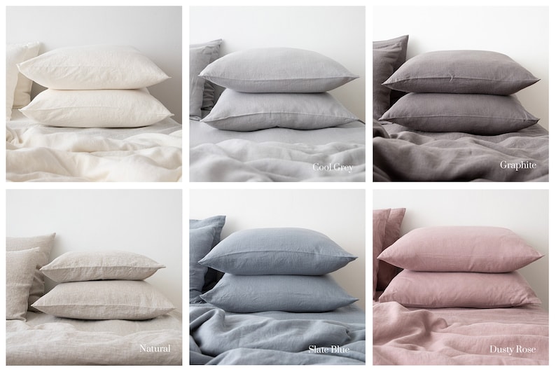 May include: Six linen pillowcases in different colors: natural, cool grey, graphite, dusty rose, slate blue, and natural. The pillowcases are stacked on top of each other on a bed.