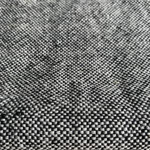 May include: Close-up of a black and white textured fabric with a woven pattern.