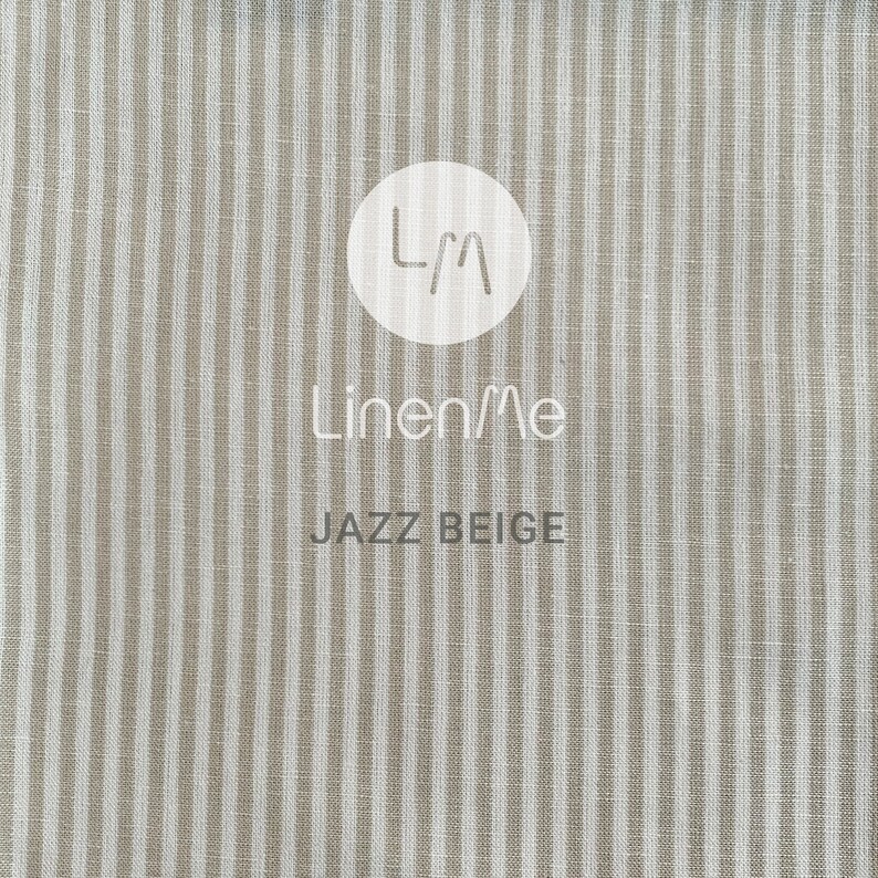 May include: Beige linen fabric with white stripes. The fabric has a subtle texture and a slightly rough feel. The fabric is labelled "LinenMe Jazz Beige".