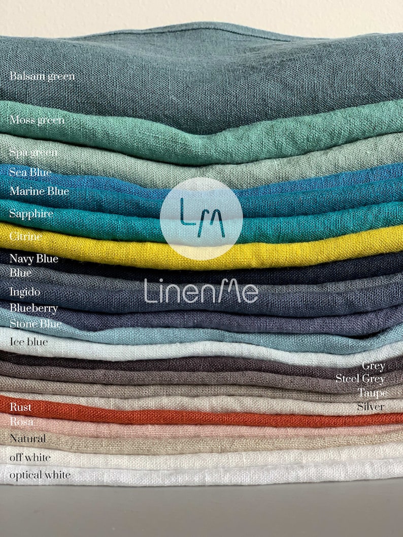 May include: A stack of linen fabric swatches in various colors, including balsam green, moss green, sea blue, marine blue, sapphire, citrine, navy blue, blue, indigo, blueberry, stone blue, ice blue, rust, rosa, natural, off white, and optical white. The swatches are labeled with their corresponding color names. The text "Linen/Me" is visible in the center of the image.