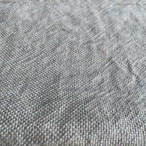 May include: Close-up of a beige woven fabric with a textured surface.