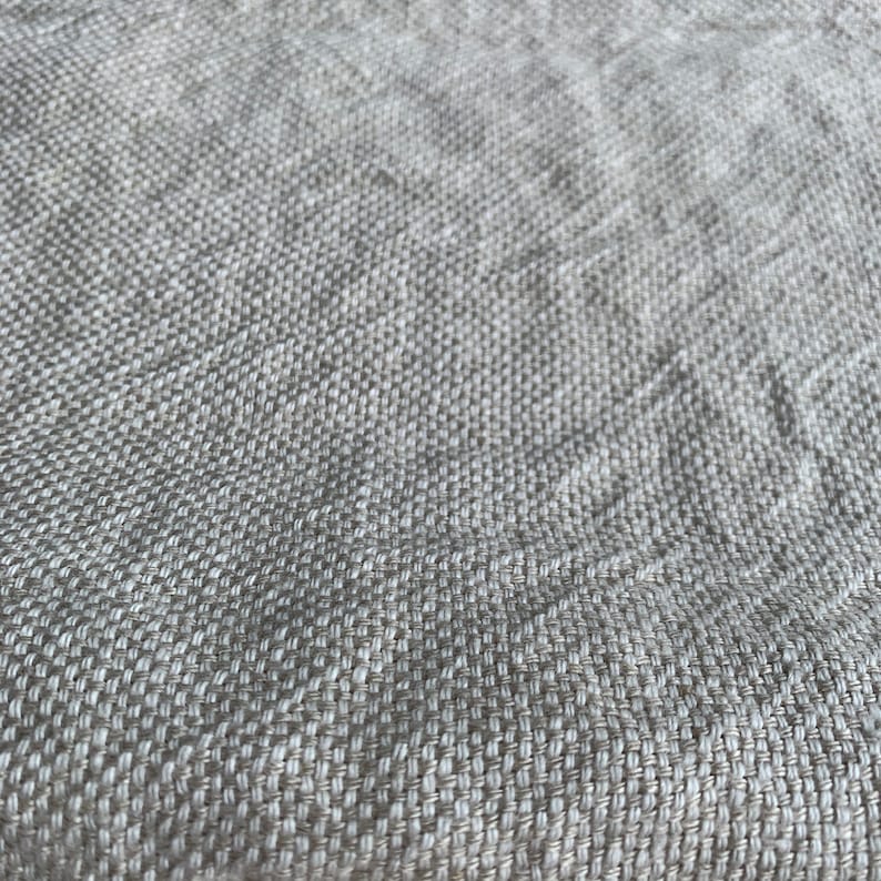 May include: Close-up of a beige woven fabric with a textured surface.