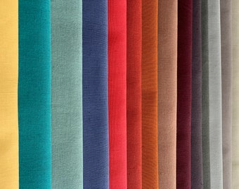 Puede incluir: Una colección de muestras de tela en varios colores, incluyendo amarillo, verde azulado, verde, azul, rojo, naranja, marrón, beige, burdeos, gris y blanco. La tela tiene una textura de lino.