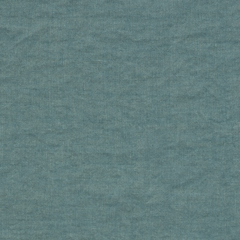 May include: A close-up of a textured, blue fabric. The fabric has a subtle woven pattern.