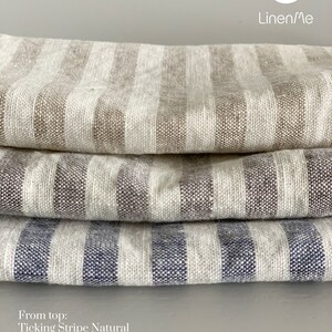 May include: Three fabric swatches stacked on top of each other. The top swatch is a natural ticking stripe, the middle swatch is a graphite ticking stripe, and the bottom swatch is an indigo ticking stripe. The text "From top: Ticking Stripe Natural, Ticking Stripe Graphite, Ticking Stripe Indigo" is below the swatches. The text "LM Linen/Me" is in the top right corner of the image.