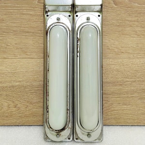 Könnte beinhalten: Zwei vintage Leuchten aus silbernem Metall mit Glaseinsätzen. Die Leuchten tragen die Aufschrift "BKU" und "B048".