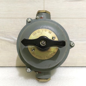 May include: A gray, industrial-style electrical component with a black handle and brass fittings. The component has a circular shape with visible screws and text, including "ПВ3-25" and "56".