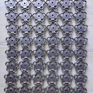 Puede incluir: Una colección de 42 pomos de metal de color plateado con un diseño de estrella de seis puntas. Cada pomo tiene un pequeño agujero en el centro.